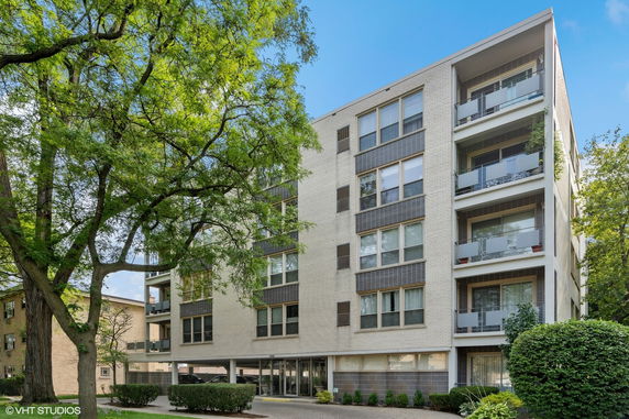 Front view of a multi-story apartment building with balconies.