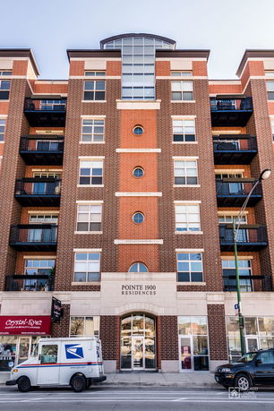 Front view of a multi-story apartment building with balconies.