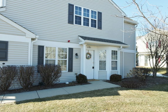 Front view of a two-story house with a covered entrance and multiple windows.