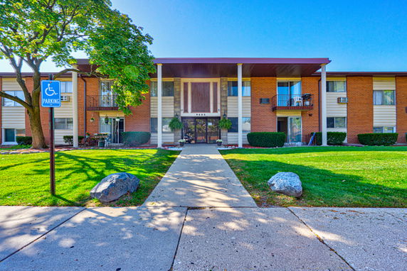Front view of a multi-story apartment building with balconies.