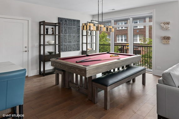 Room with a pool table and large windows.