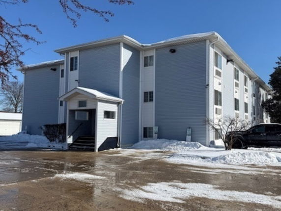 Front view of a multi-story residential building in a snowy environment.