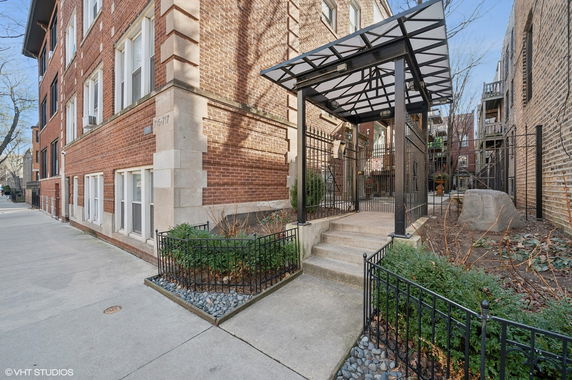 Front view of a multi-story brick building with a covered entrance.
