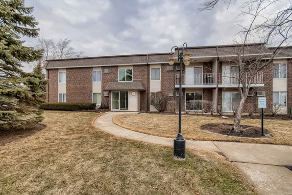 Front view of a two-story apartment building with brick facade.