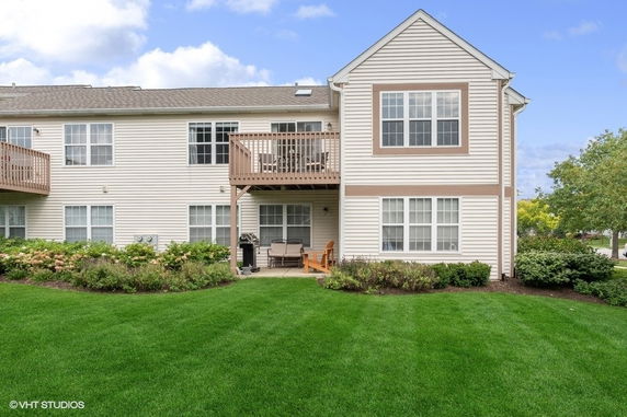 Front view of a two-story house with a balcony and patio area.