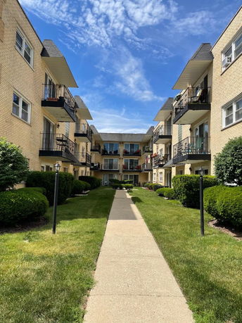 Front view of a multi-story apartment building with balconies.