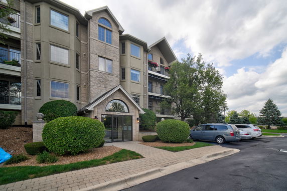 Front view of a multi-story residential building with a brick and stucco facade.