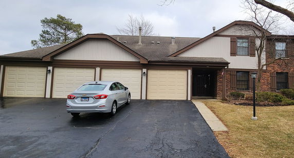 Front view of a multi-family residential building with attached garages.