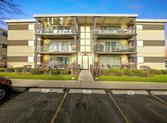 Front view of a three-story apartment building with balconies.