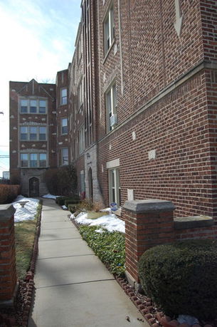 Front view of a multi-story brick apartment building.