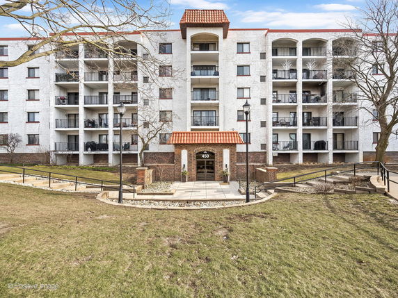 Front view of a multi-story residential building with balconies.