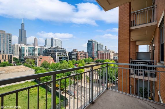 View from a balcony overlooking a cityscape with modern buildings.