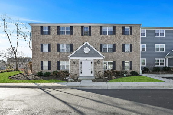 Front view of a three-story brick building with a symmetrically aligned facade and a central entrance.