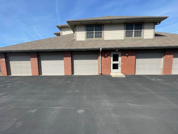 Front view of a two-story building with multiple garage doors and a second floor with windows.
