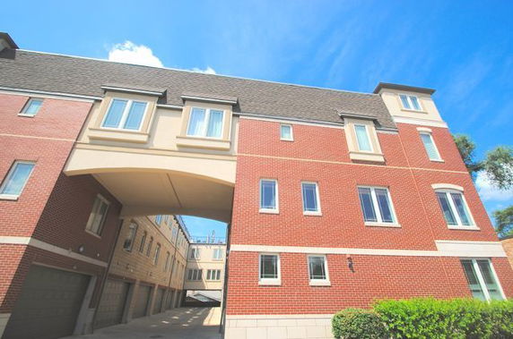 Front view of a multi-story building with brick facade and a large archway.