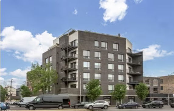Front view of a multi-story apartment building with balconies.