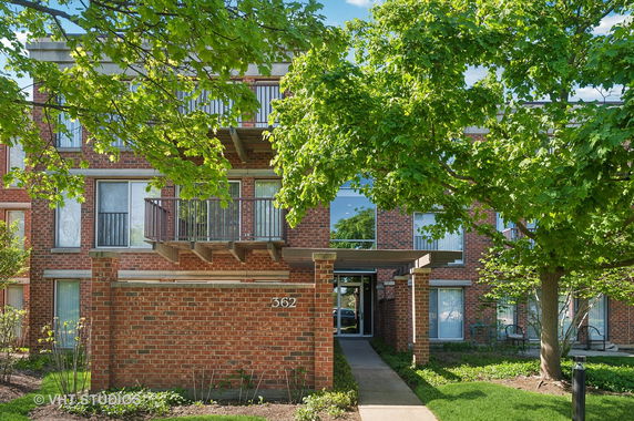 Front view of a brick apartment building with balconies.