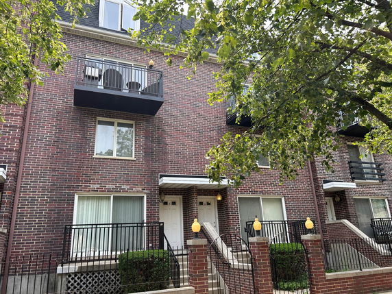 Front view of a multi-story brick building with balconies.