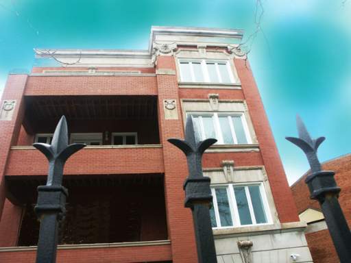Front view of a multi-story brick building with decorative elements.