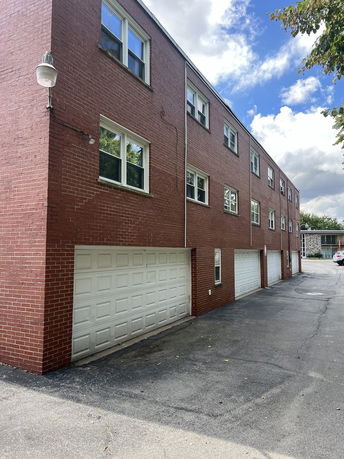 Front view of a multi-story brick building with multiple garages.
