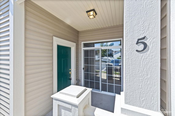 Front view of a house entrance with a green door and glass sliding doors.