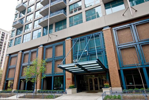 Front view of a multi-story building with a glass entrance and balconies.