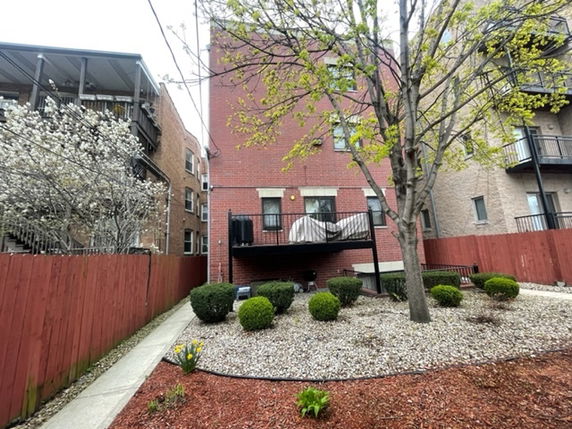 Rear view of a multi-story brick building with a balcony