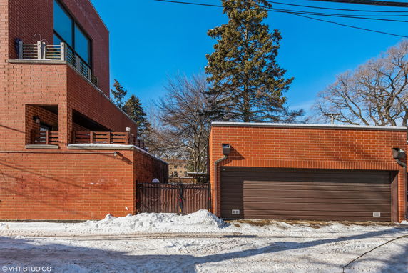 Front view of a brick house with a balcony and a double garage.
