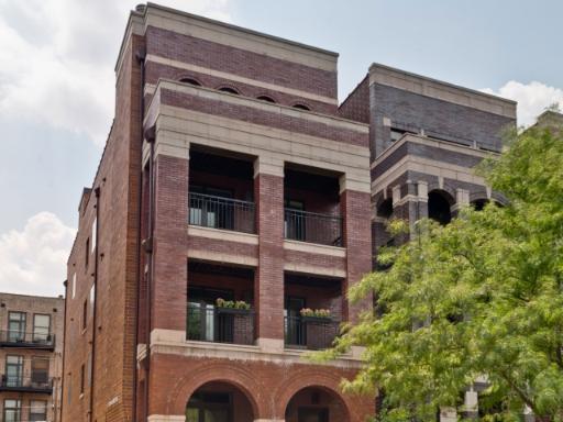 Front view of a multi-story brick building with balconies.