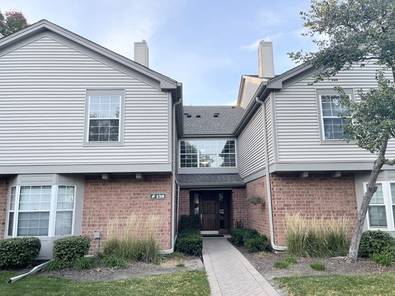 Front view of a two-story house with brick and siding exterior.