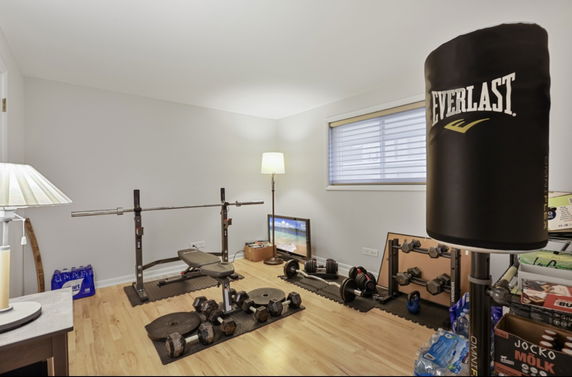 Indoor gym area with weightlifting equipment and a punching bag.