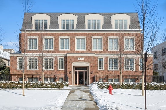 Front view of a multi-story brick building with large windows.