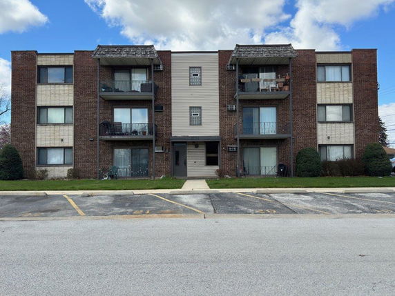 Front view of a multi-story apartment building with balconies.