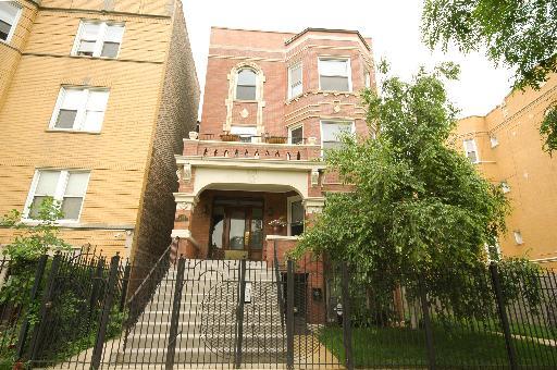 Front view of a multi-story brick building with steps leading to the entrance.
