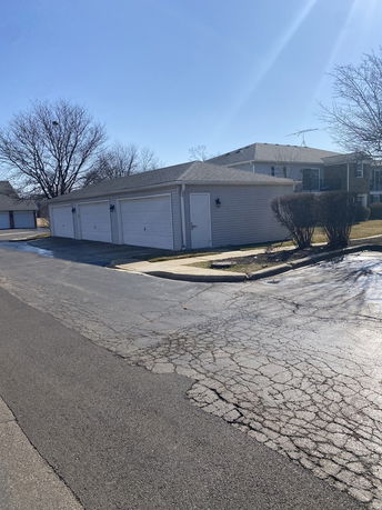 Outdoor parking area with a detached garage structure.