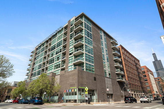 Front view of a multi-story building with glass windows and balconies.