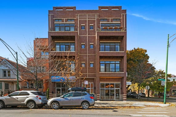 Front view of a multi-story brick building with balconies.