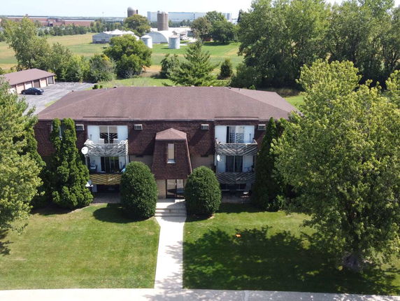 Front view of a two-story building with balconies and a brown roof.