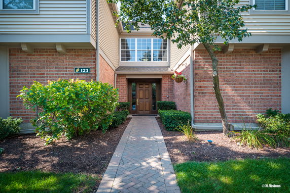 Front view of a house with a brick facade and wooden door.