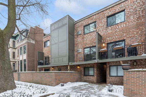 Front view of a multi-story brick residential building with balconies.