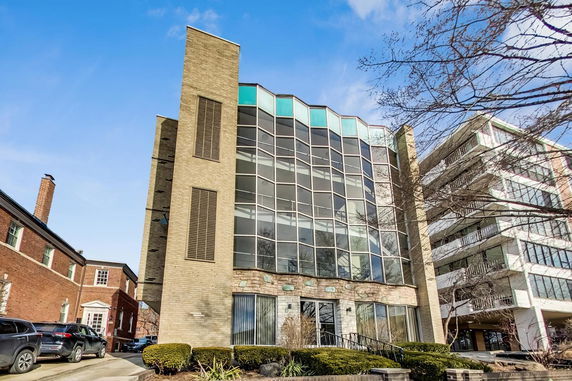 Front view of a modern multi-story building with large glass windows.