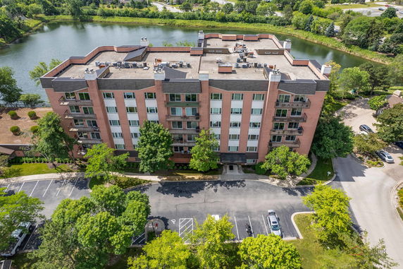 Elevated view of a multi-story brick residential building with a flat rooftop and balconies.