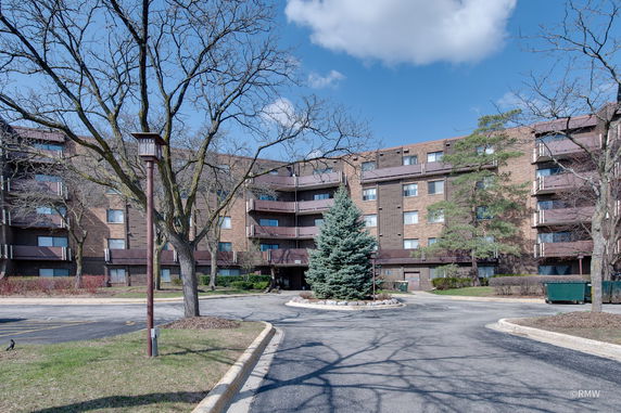 Front view of a multi-story apartment building with balconies.