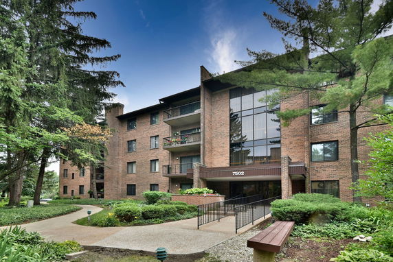 Front view of a multi-story brick apartment building with balconies.