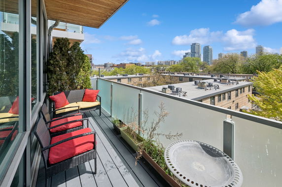 Balcony with seating and view of urban buildings and skyline