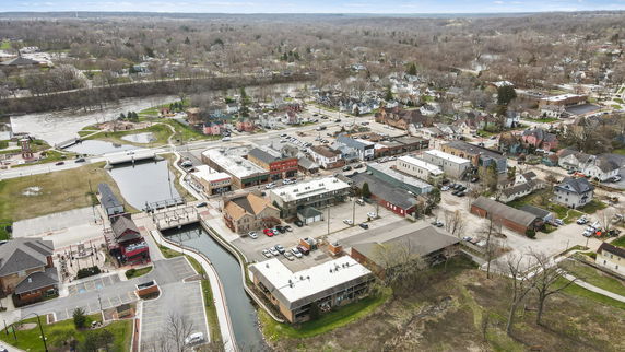 Aerial view of a town with multiple buildings, roads, and a river.