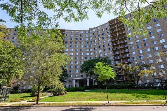 Front view of a multi-story apartment building with numerous windows and balconies.