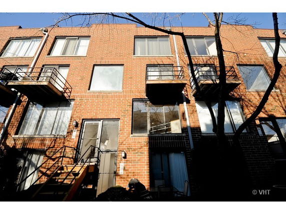 Front view of a multi-story brick building with small balconies.