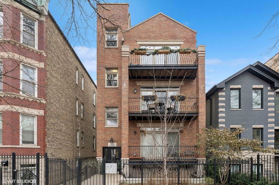 Front view of a multi-story brick building with balconies.