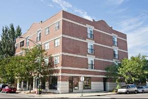 Front view of a four-story brick building with multiple windows.